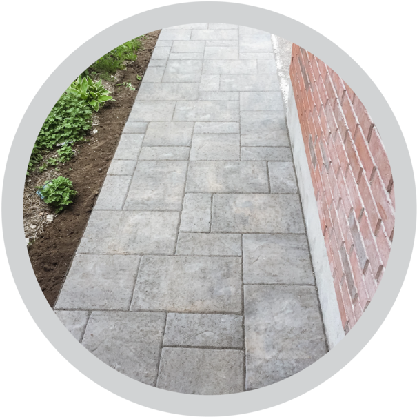 Paved Cobblestone Pathway Nextto Brick Wall