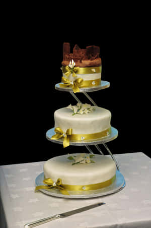 Elegant Three Tier Wedding Cakewith Gold Ribbons PNG image with transparent background