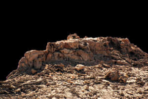 Rocky_ Outcrop_ Against_ Dark_ Background.jpg PNG with transparent background