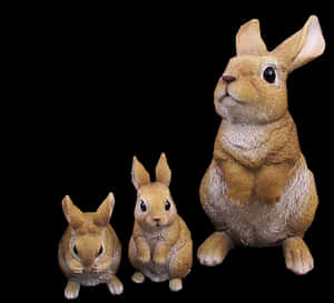 Three Rabbit Figurines Black Background PNG image with transparent background
